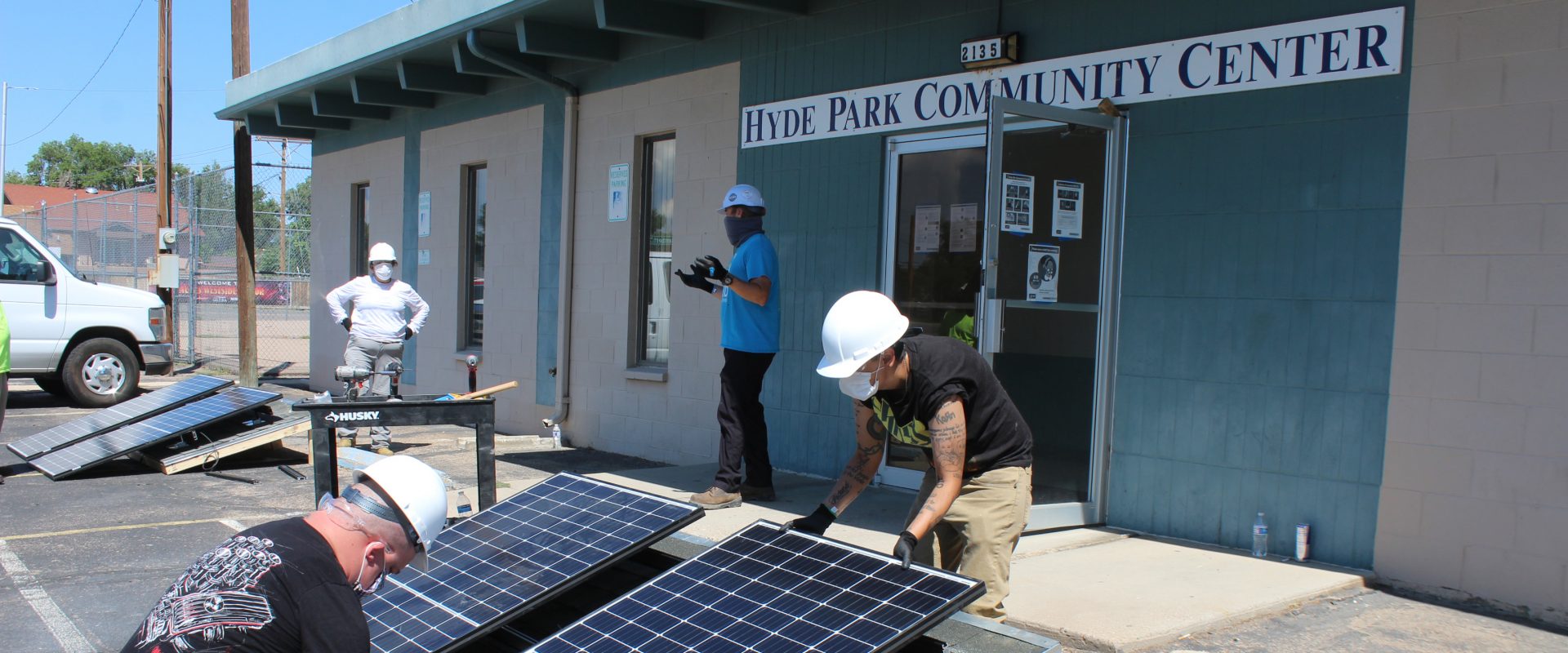 workers working on solar panels outside Hyde Park Community Center