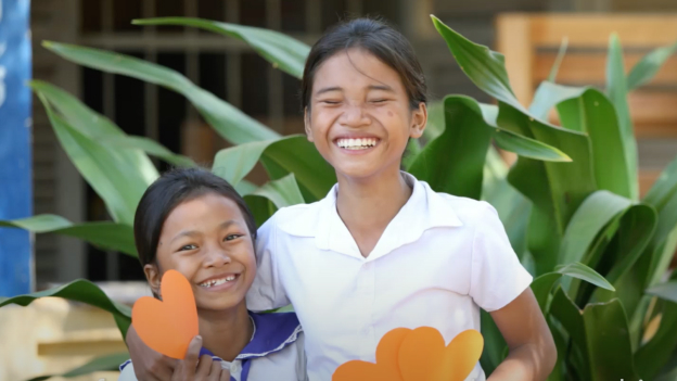 Smiling children holding heart-shaped cards