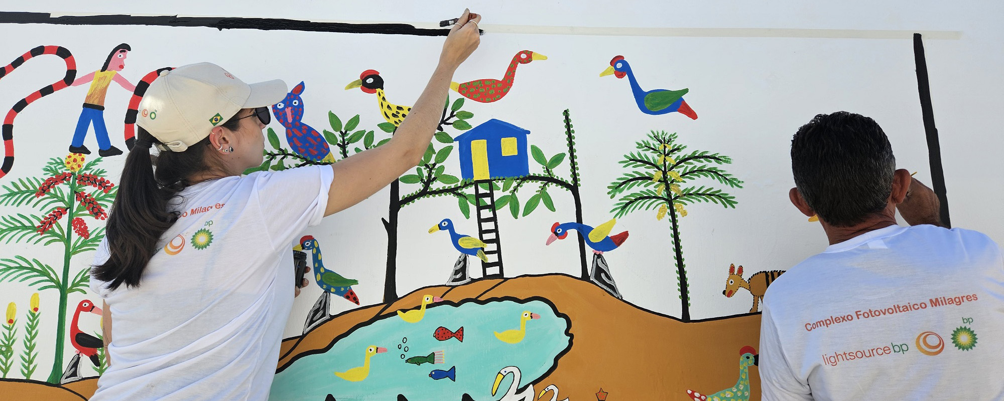 Lightsource bp team member painting a mural on school wall